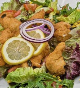 Salat gebackene Hühnerstreifen, leicht und knusprig, mit Salat der Saison