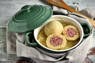 Wurstknödel, Haschee, Fleisch? Alles ist möglich, nichts ist Pflicht! 

Wurst verschiedenster Art gehüllt in einen fluffigen Teig aus Kartoffel. Wurstreste, Bratenreste, Schinken, Suppenfleisch, alles kann verarbeitet werden. Die Methode ist immer die gleiche. Die Frage, die sich jeder beantworten muss, ist: Schneiden oder durch den Wolf jagen! 

Wir haben in diesem Rezept mal den Fleischwolf verwendet. Unser Entschluss steht fest. Es bleibt bei einem Versuch. In Zukunft wird wieder geschnippelt. Fein geschnitten ergibt die Füllung ein besseres Mundgefühl und sorgt für mehr Struktur. 

So war es, so wird es immer sein! 

Wir haben gelernt, nichts im Leben zu verschwenden und alles so gut wie möglich zu verarbeiten und zu verwerten. Das gilt auch in der Küche. Es kommt vor, dass von einer Wurst immer kleine Stücke übrig bleiben, es gibt Reste von einem Braten. 

Wir verarbeiten diese Reste zu einer feinen oder groben Füllung und packen diese in fluffigen Kartoffelteig. 

Kann man die Knödel vorbeireiten? 

Absolut! Die Knödel können vorbereitet und maximal zwei Tage im Kühlschrank verweilen, bevor sie zubereitet werden. Vor der Zubereitung aus der Kühlung nehmen, ca. 10 Minuten stehen lassen, in der Zwischenzeit das Wasser aufkochen und salzen, Hitze reduzieren und die Knödel im Wasser sanft garen. 

Kann man die Knödel einfrieren? 

Ja, nach der Vorbereitung ist es kein Problem, die Knödel einzufrieren und bei Bedarf zu kochen. Mach kann sie gleich als gefrorener ins Wasser geben oder leicht antauen lassen. Sind die Knödel gegart, bitte nicht mehr einfrieren, sondern in den nächsten 1 bis 2 Tagen erwärmen und verzehren.

#aufunsereart #rezept #kochen #knödel #wurst #genuss #handgemacht